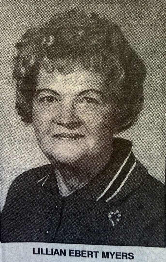 Black and white portrait of an elderly woman smiling gently.