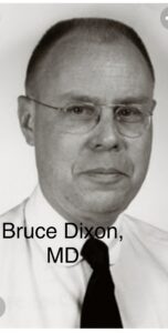 Portrait of an older man wearing glasses and a white shirt.
